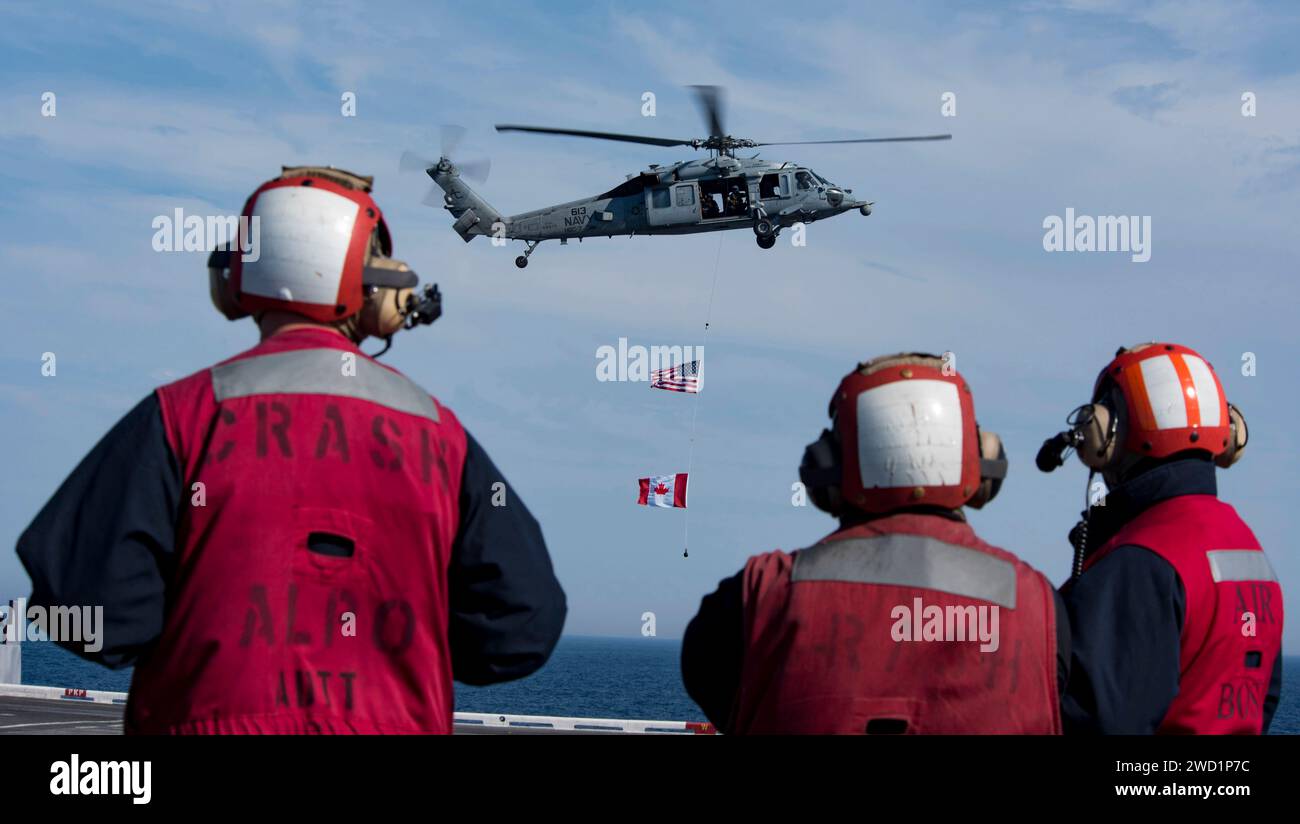 Les marins observent un MH-60S Sea Hawk lors d'une démonstration de puissance aérienne à bord de l'USS Dwight D. Eisenhower. Banque D'Images