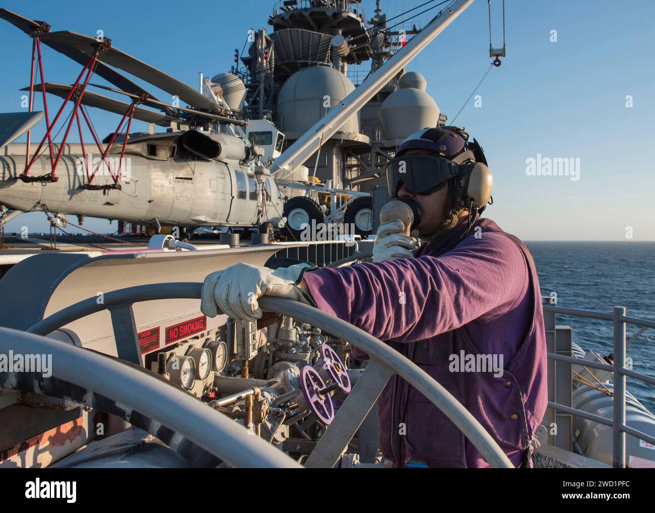 Viation Boatswains Mate dirige son équipage lors d'une évolution de ravitaillement à bord de l'USS Wasp. Banque D'Images