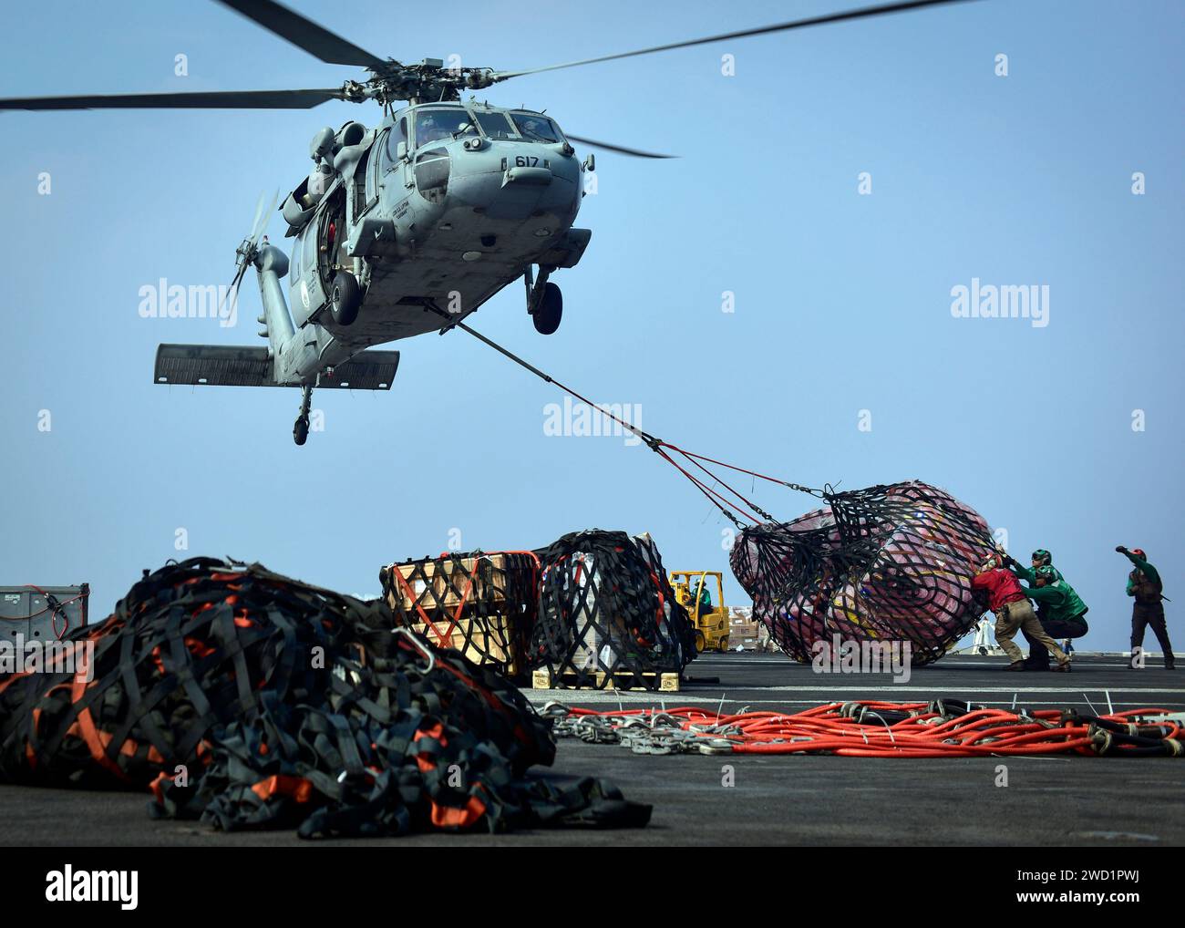 Les marins reçoivent des fournitures d'un hélicoptère MH-60S Sea Hawk à bord de l'USS Nimitz. Banque D'Images