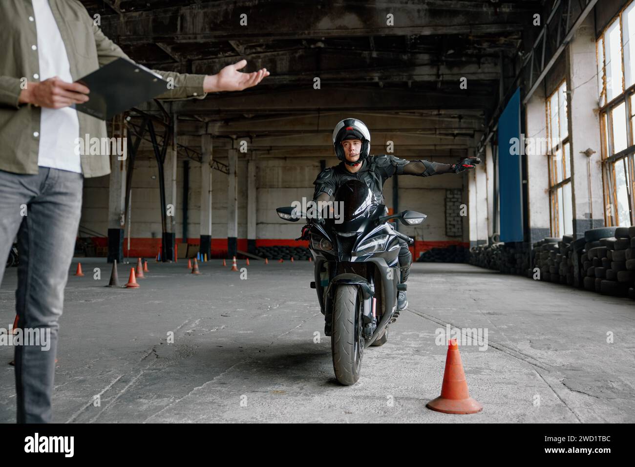 Étudiant apprenant à conduire une moto avec une main Banque D'Images