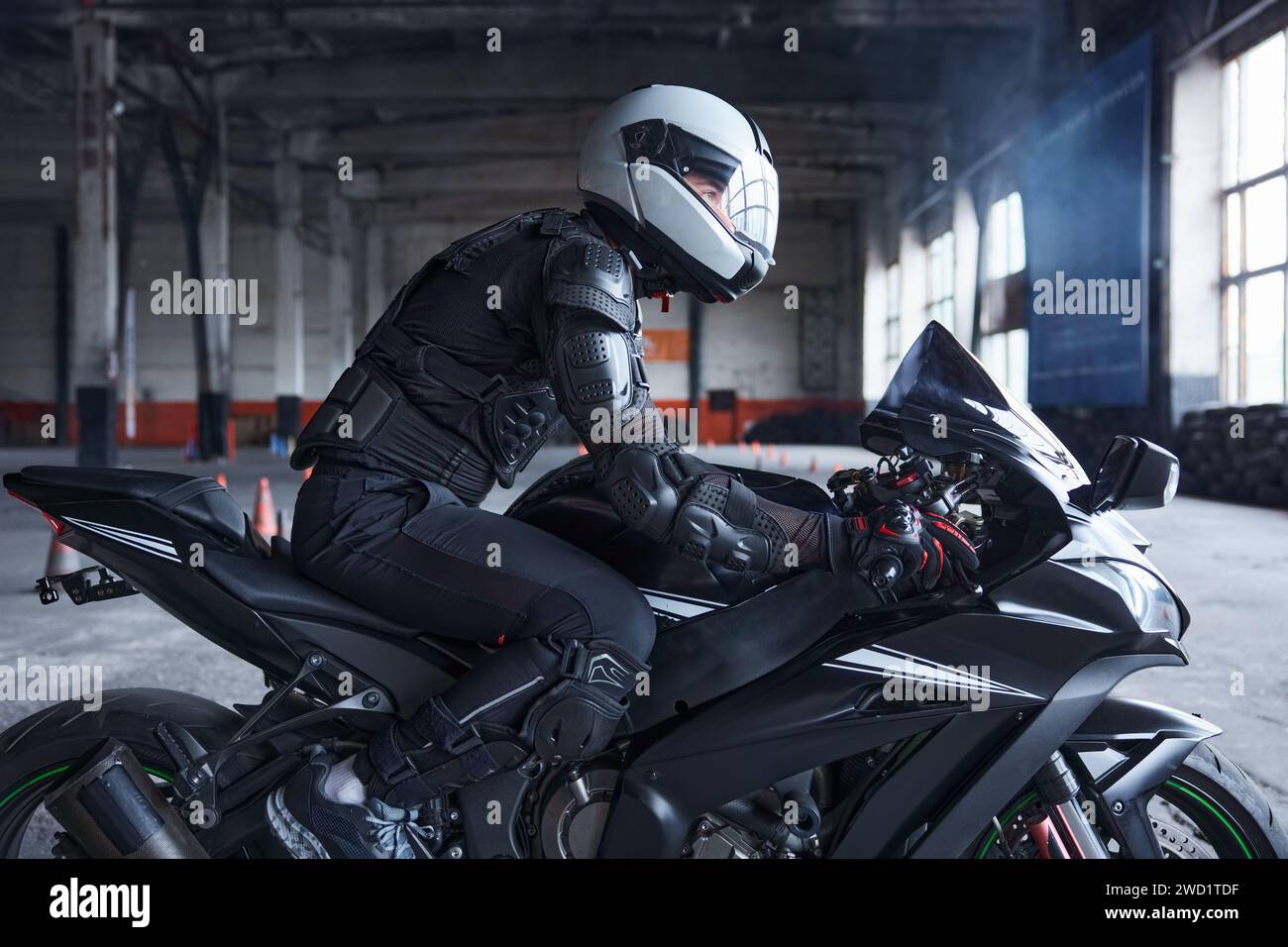 Biker portant un casque de protection et un uniforme pour la conduite de vitesse à la classe d'entraînement Banque D'Images