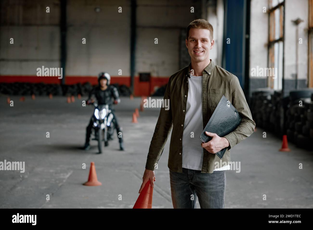 Portrait de l'heureux instructeur souriant de l'école de conduite au motordrome de formation Banque D'Images