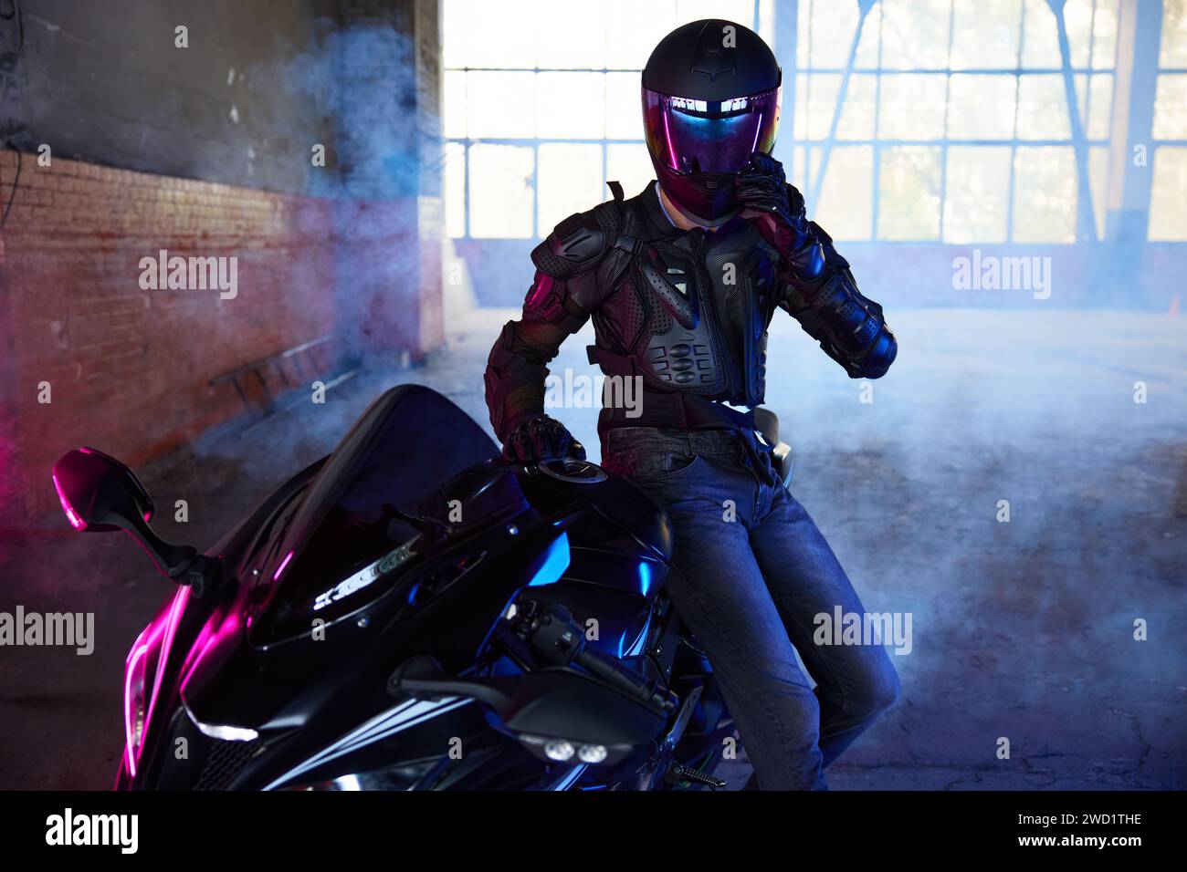 Portrait d'homme coureur extrême assis à moto prenant le repos après l'entraînement Banque D'Images
