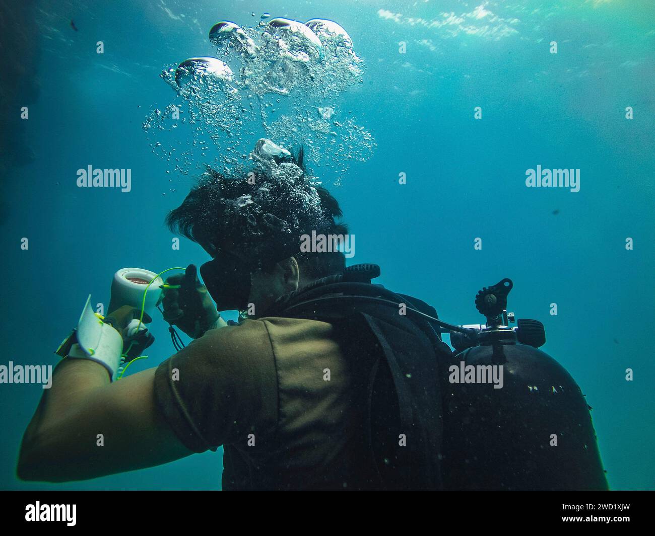 Un plongeur de la marine américaine enregistre les mesures du bathycorromètre pendant les opérations DE PLONGÉE dans le port de Tinian. Banque D'Images
