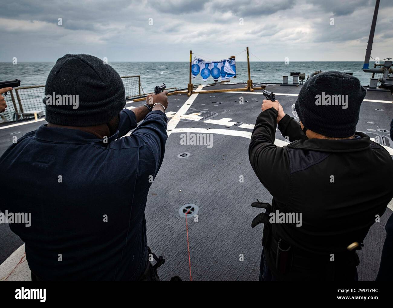 Les marins tirent des pistolets de service M9 lors d'un tir d'armes légères sur le pont d'envol à bord de l'USS John S. McCain. Banque D'Images