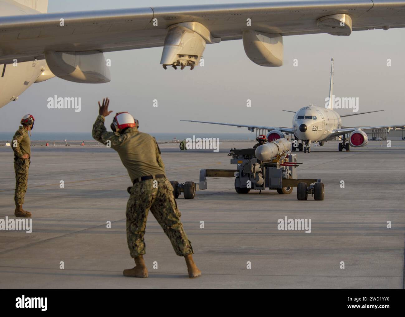 Aviation Ordnanceman dirige le chargement d'un missile harpon AGM-84D sur un P-8a Poséidon. Banque D'Images