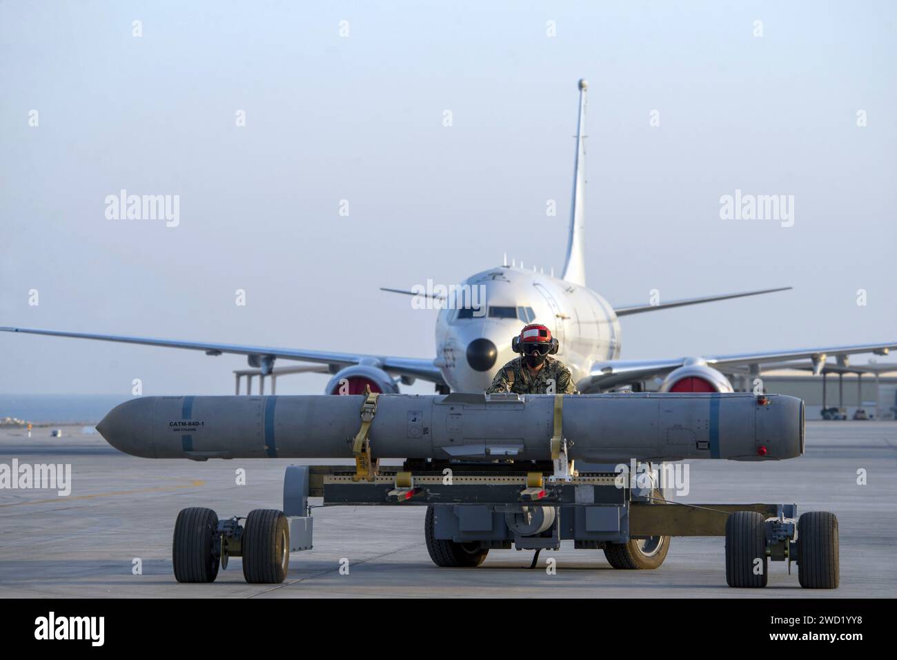 Aviation Ordnanceman se prépare à charger un missile harpon AGM-84D sur un P-8a Poséidon. Banque D'Images