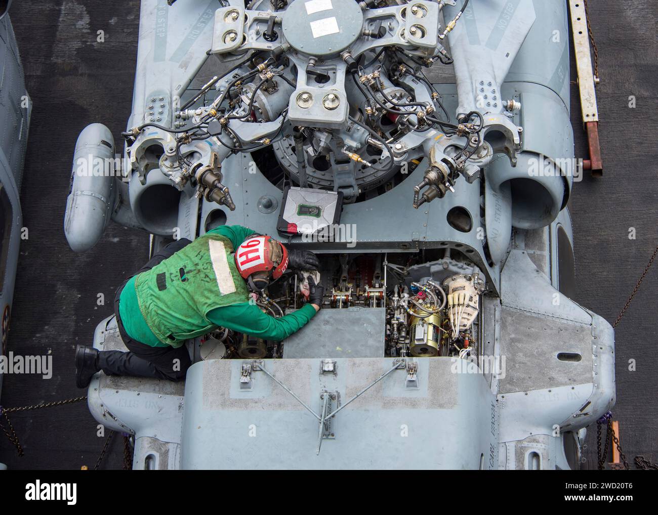 Un marin américain effectue la maintenance d'un hélicoptère MH-60S Sea Hawk sur le pont d'envol de l'USS Carl Vinson. Banque D'Images