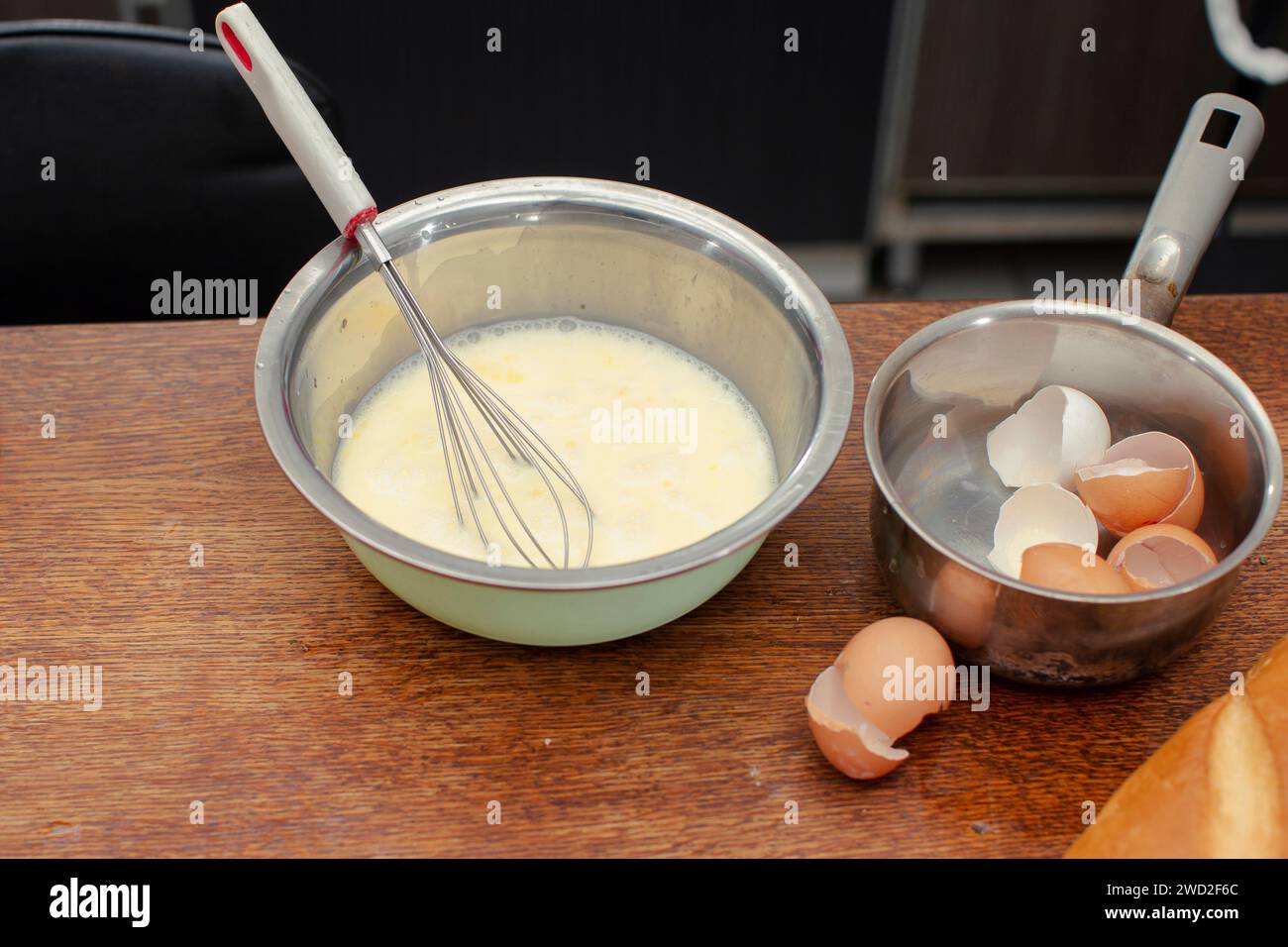 Dans un bol, il y a un mélange pour faire une omelette et des coquilles pour les œufs. Banque D'Images