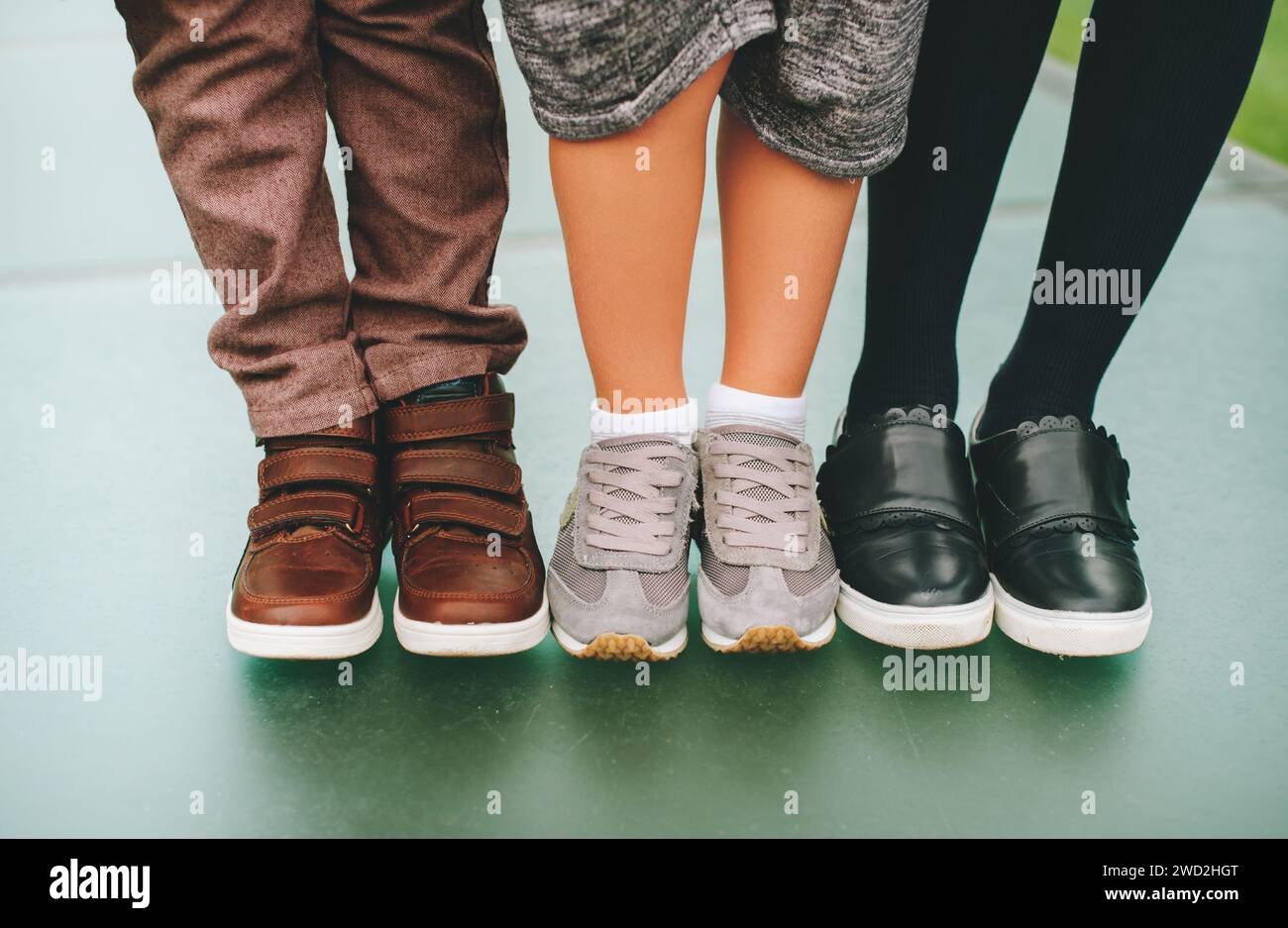 Chaussures de mode pour enfants. Trois paires de pieds pour enfants portant des baskets confortables et tendance. Concept de retour à l'école Banque D'Images