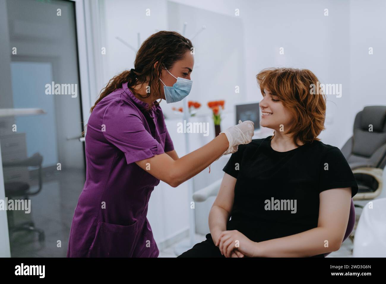 Un dentiste expérimente de nouvelles nuances de dents pour prothèses dans un cabinet dentaire, mettant en valeur la précision et l'innovation dans les soins dentaires Banque D'Images