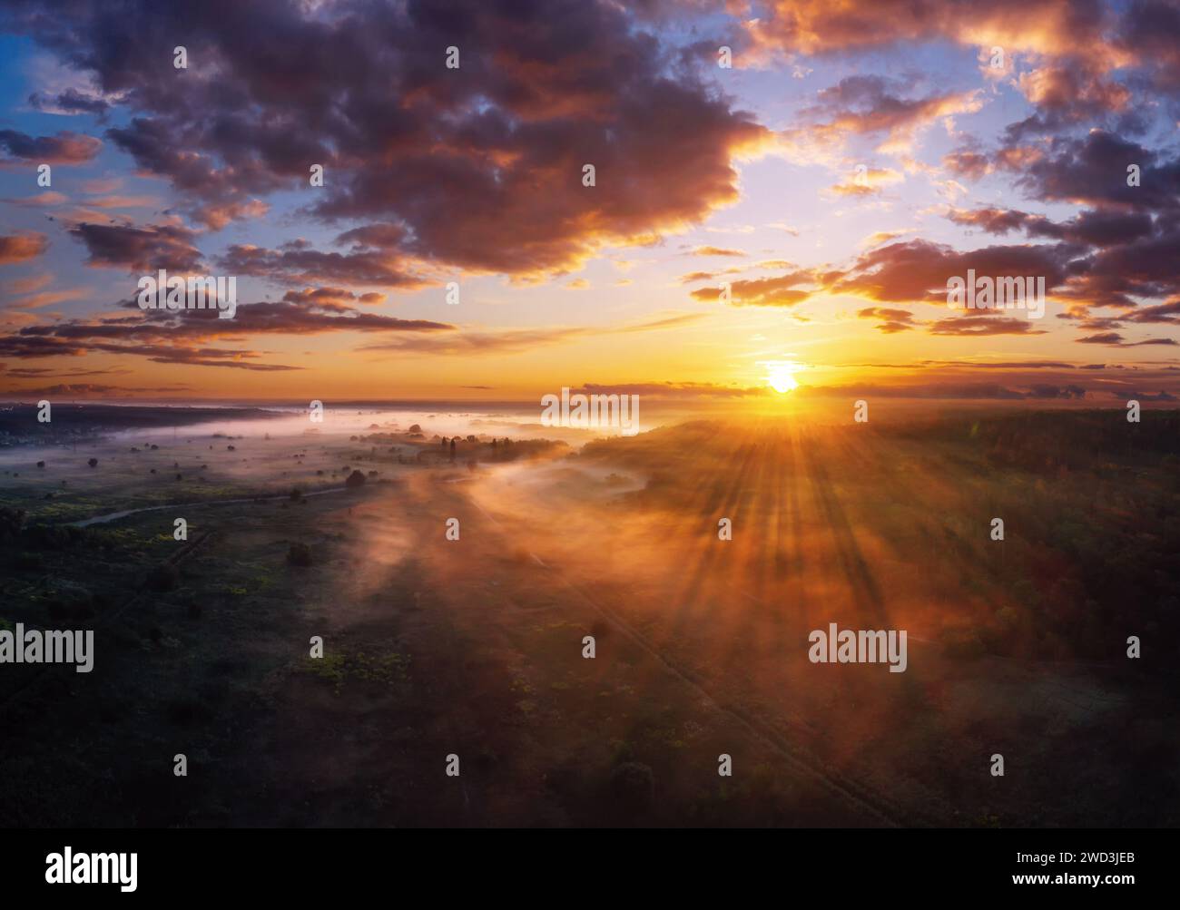Paysage matinal coloré avec un ciel spectaculaire sur le champ brumeux au coucher du soleil depuis la vue aérienne. Banque D'Images