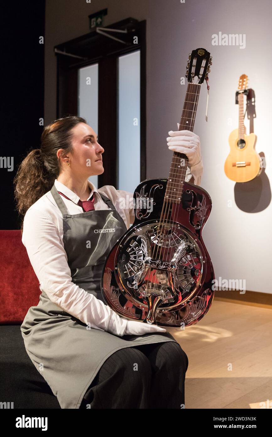 LONDRES, ROYAUME-UNI - 18 JANVIER 2023 : un membre du personnel tient une guitare à résonateur, Dobro Duolian, Original musical instrument Company, Huntington Beach, Californie, vers 1995, estimation : £1 500-2 500 lors d'un photocall à la maison de vente aux enchères Christie's présentant les temps forts de la collection personnelle de Mark Knopfler, chanteur du groupe britannique emblématique, dire Straits, à Londres, au Royaume-Uni, le 18 janvier 2023. Les guitares seront offertes lors d’une vente aux enchères le 31 janvier et 25% du prix total du marteau seront reversés aux associations caritatives de la Croix-Rouge britannique, Tusk et Brave Hearts of the North East Banque D'Images