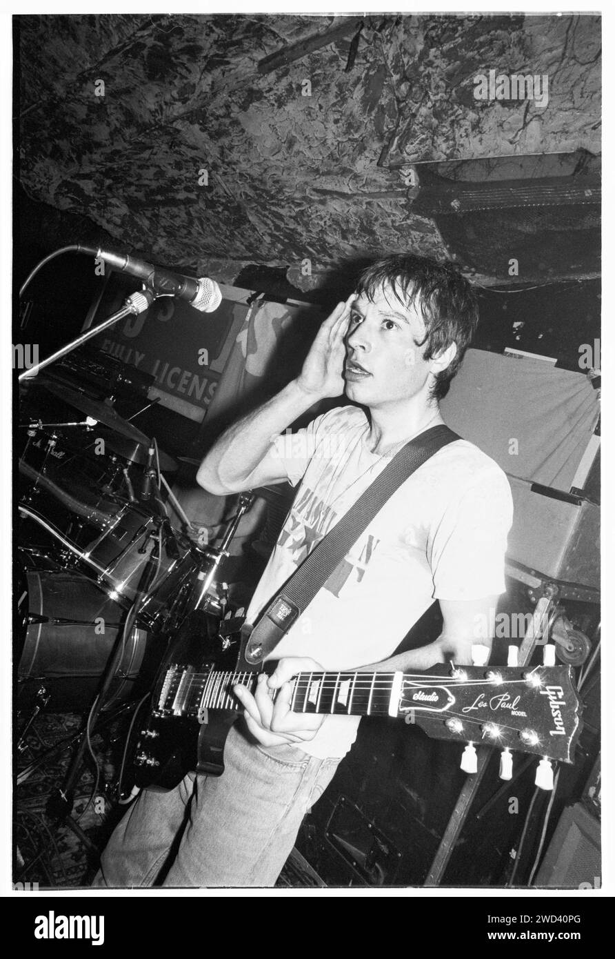 Ed Borrie du groupe punk S*M*A*S*H (SMASH) jouant en live au légendaire TJ's à Newport, pays de Galles, Royaume-Uni, le 21 mars 1994. Photo : Rob Watkins. INFO : SMASH, un groupe de punk britannique des années 90, a adopté l'éthique DIY. Leur son énergique, alimenté par des paroles politiquement chargées, a trouvé la suite. Des hymnes comme « Je veux tuer quelqu'un » et « honte » ont capturé l'esprit rebelle de la scène punk pendant leurs années actives. Banque D'Images
