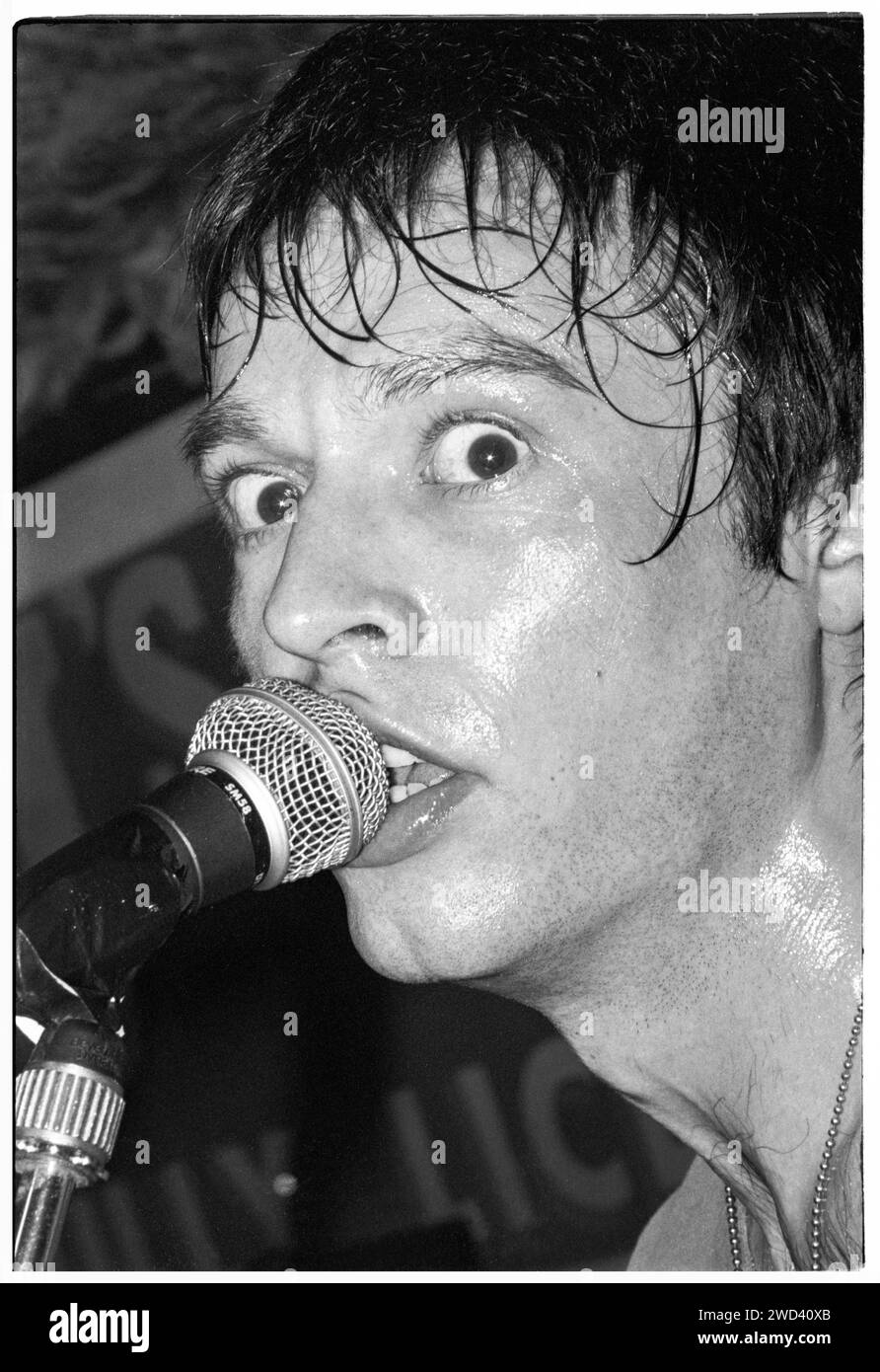 Ed Borrie du groupe punk S*M*A*S*H (SMASH) jouant en live au légendaire TJ's à Newport, pays de Galles, Royaume-Uni, le 21 mars 1994. Photo : Rob Watkins. INFO : SMASH, un groupe de punk britannique des années 90, a adopté l'éthique DIY. Leur son énergique, alimenté par des paroles politiquement chargées, a trouvé la suite. Des hymnes comme « Je veux tuer quelqu'un » et « honte » ont capturé l'esprit rebelle de la scène punk pendant leurs années actives. Banque D'Images