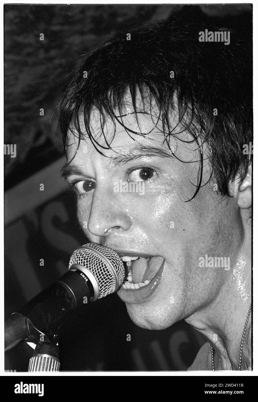Ed Borrie du groupe punk S*M*A*S*H (SMASH) jouant en live au légendaire TJ's à Newport, pays de Galles, Royaume-Uni, le 21 mars 1994. Photo : Rob Watkins. INFO : SMASH, un groupe de punk britannique des années 90, a adopté l'éthique DIY. Leur son énergique, alimenté par des paroles politiquement chargées, a trouvé la suite. Des hymnes comme « Je veux tuer quelqu'un » et « honte » ont capturé l'esprit rebelle de la scène punk pendant leurs années actives. Banque D'Images