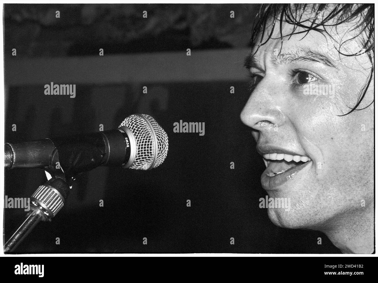 Ed Borrie du groupe punk S*M*A*S*H (SMASH) jouant en live au légendaire TJ's à Newport, pays de Galles, Royaume-Uni, le 21 mars 1994. Photo : Rob Watkins. INFO : SMASH, un groupe de punk britannique des années 90, a adopté l'éthique DIY. Leur son énergique, alimenté par des paroles politiquement chargées, a trouvé la suite. Des hymnes comme « Je veux tuer quelqu'un » et « honte » ont capturé l'esprit rebelle de la scène punk pendant leurs années actives. Banque D'Images