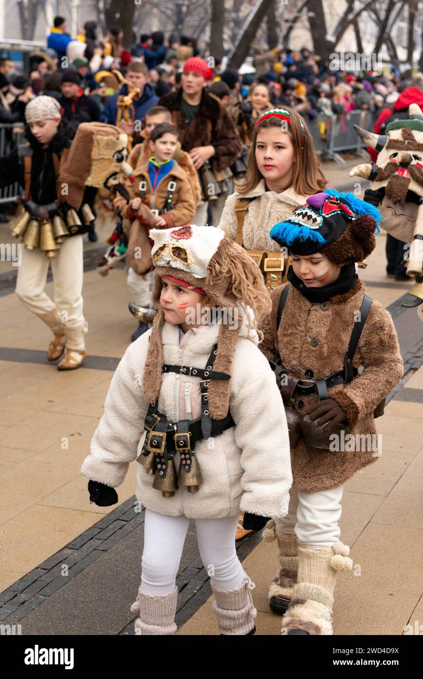Enfants en costumes de peau d'animal Kukeri au Festival international de mascarade et Mummers de Surva à Pernik, Bulgarie, Europe de l'est, Balkans, UE Banque D'Images