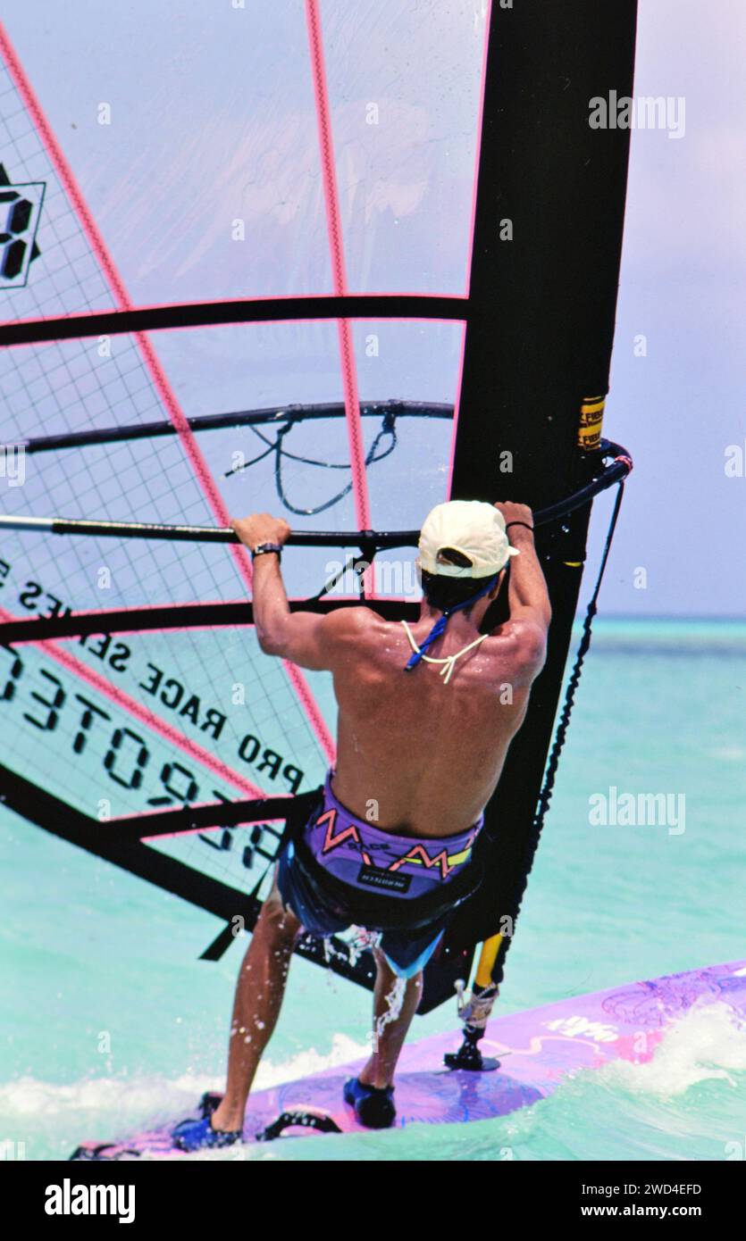 Un jeune homme planche à voile (planche à voile) dans les eaux au large d'Aruba ca. Milieu des années 1990 Veuillez créditer photographe : Joan Iaconetti. Banque D'Images