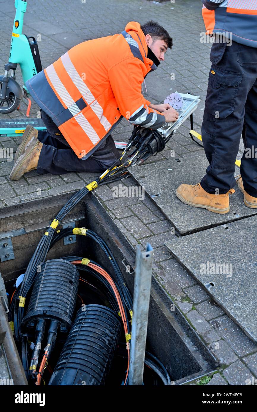 Instillation de câbles à fibres optiques dans la boîte de jonction dans les travaux de canards souterrains par un ingénieur, Royaume-Uni Banque D'Images