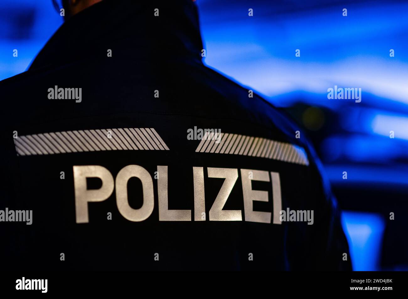 Dresde, Allemagne. 18 janvier 2024. Un policier se tient à côté d'une voiture de police. Crédit : Robert Michael/dpa/Alamy Live News Banque D'Images
