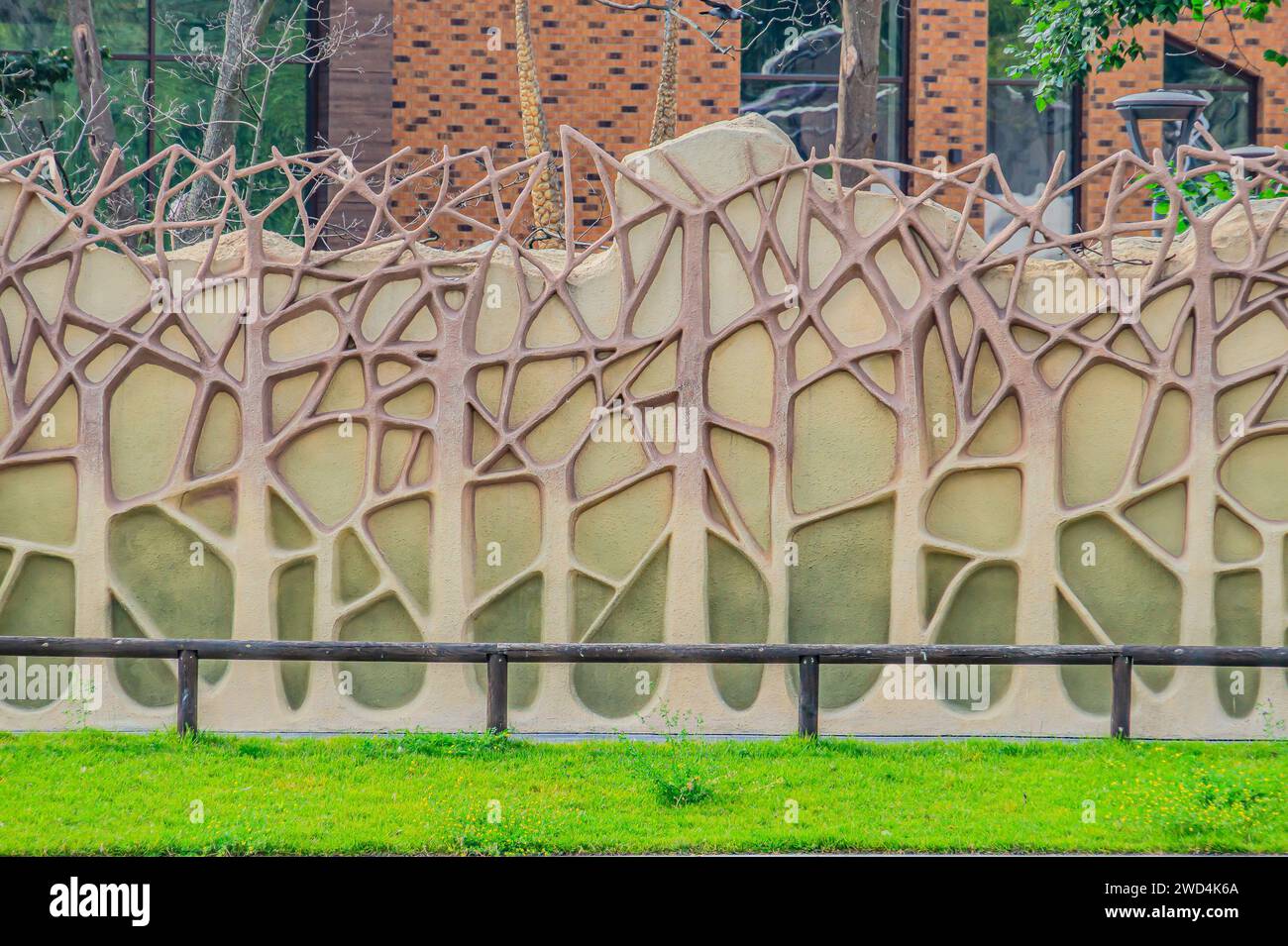 une clôture en béton faite pour ressembler à une forêt artificielle. Texture des troncs et des branches des arbres. Jardin mural vertical qui utilise la feuille artificielle verte, BE Banque D'Images