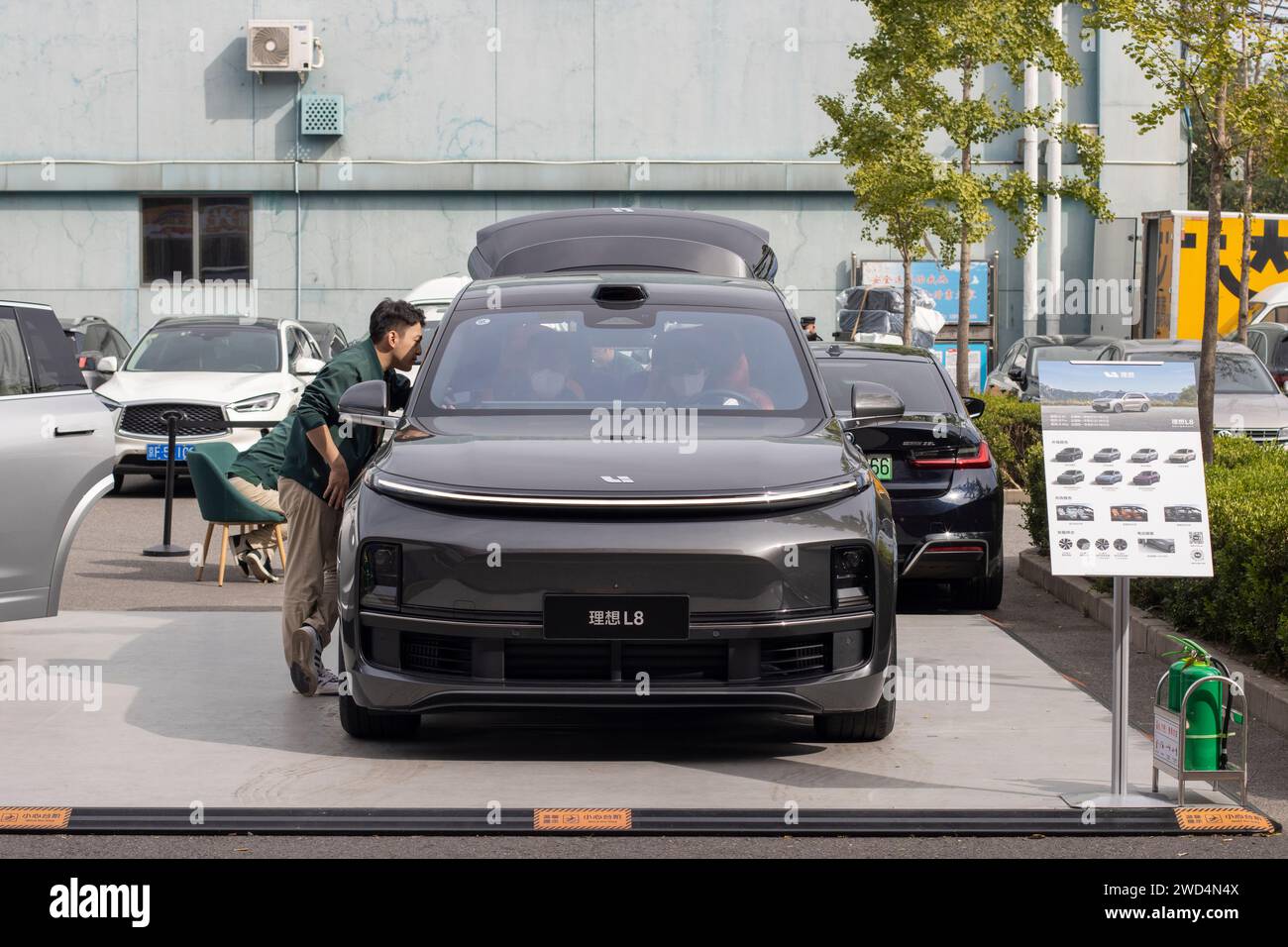 Un vendeur offre aux clients une visite physique du SUV électrique Li L8 sur un stand extérieur dans les magasins Yansha Outlets à Pékin, en Chine, mercredi... Banque D'Images
