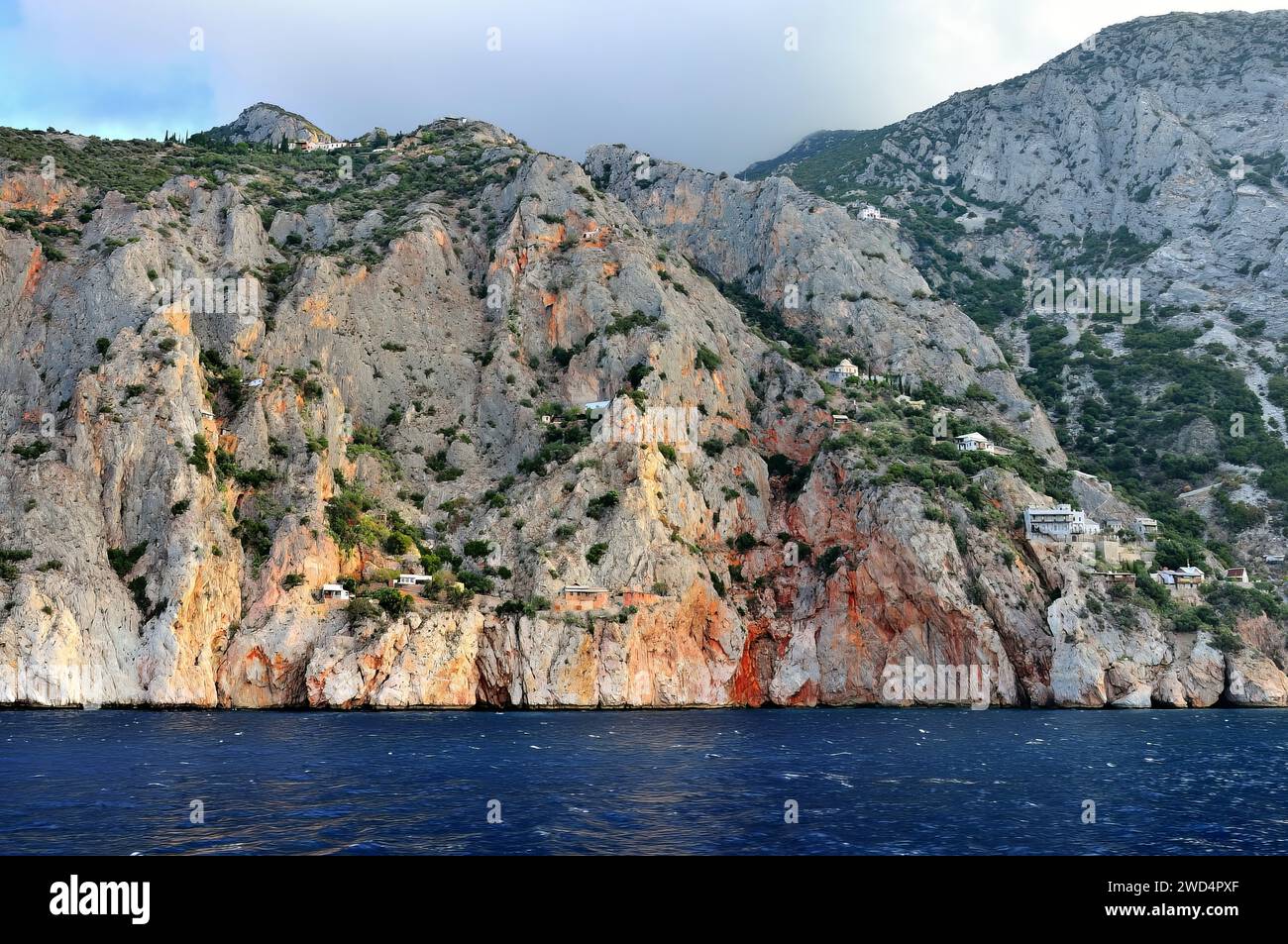 Vagues océaniques s'écrasant contre des collines ondulantes en arrière-plan Banque D'Images
