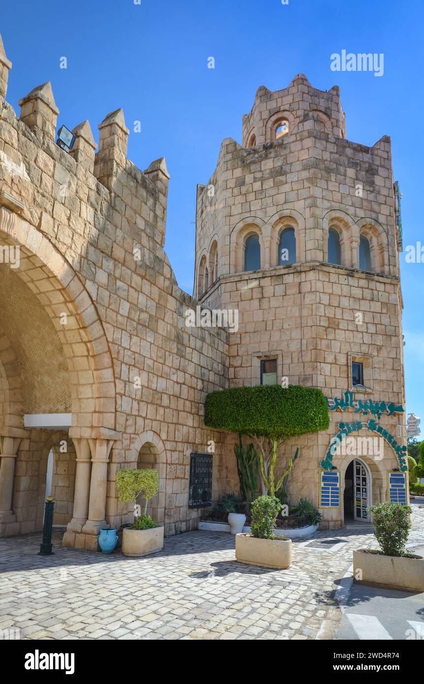 Port El Kantaoui, Sousse, Tunisie. Le portail en pierre et la tour décorent l'entrée de la rue commerçante et de la marina. Banque D'Images