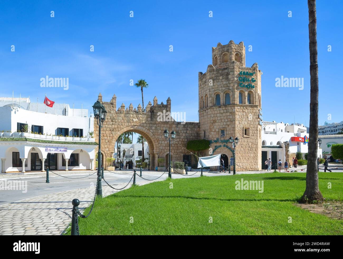 Port El Kantaoui, Sousse, Tunisie. Le portail en pierre et la tour décorent l'entrée de la rue commerçante et de la marina. Banque D'Images