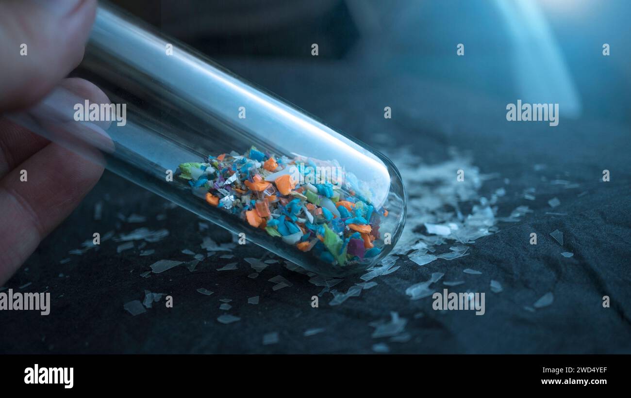 Microplastiques à l'intérieur d'un tube à essai de laboratoire en verre. Concept de pollution plastique et de gestion des déchets industriels. Banque D'Images