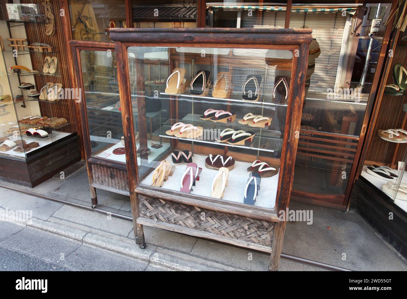 Une exposition de geta ou sandales japonaises traditionnelles dans une armoire en verre dans un ancien magasin de chaussures dans la rue Yamatooji à Gion, Kyoto, Japon. Banque D'Images