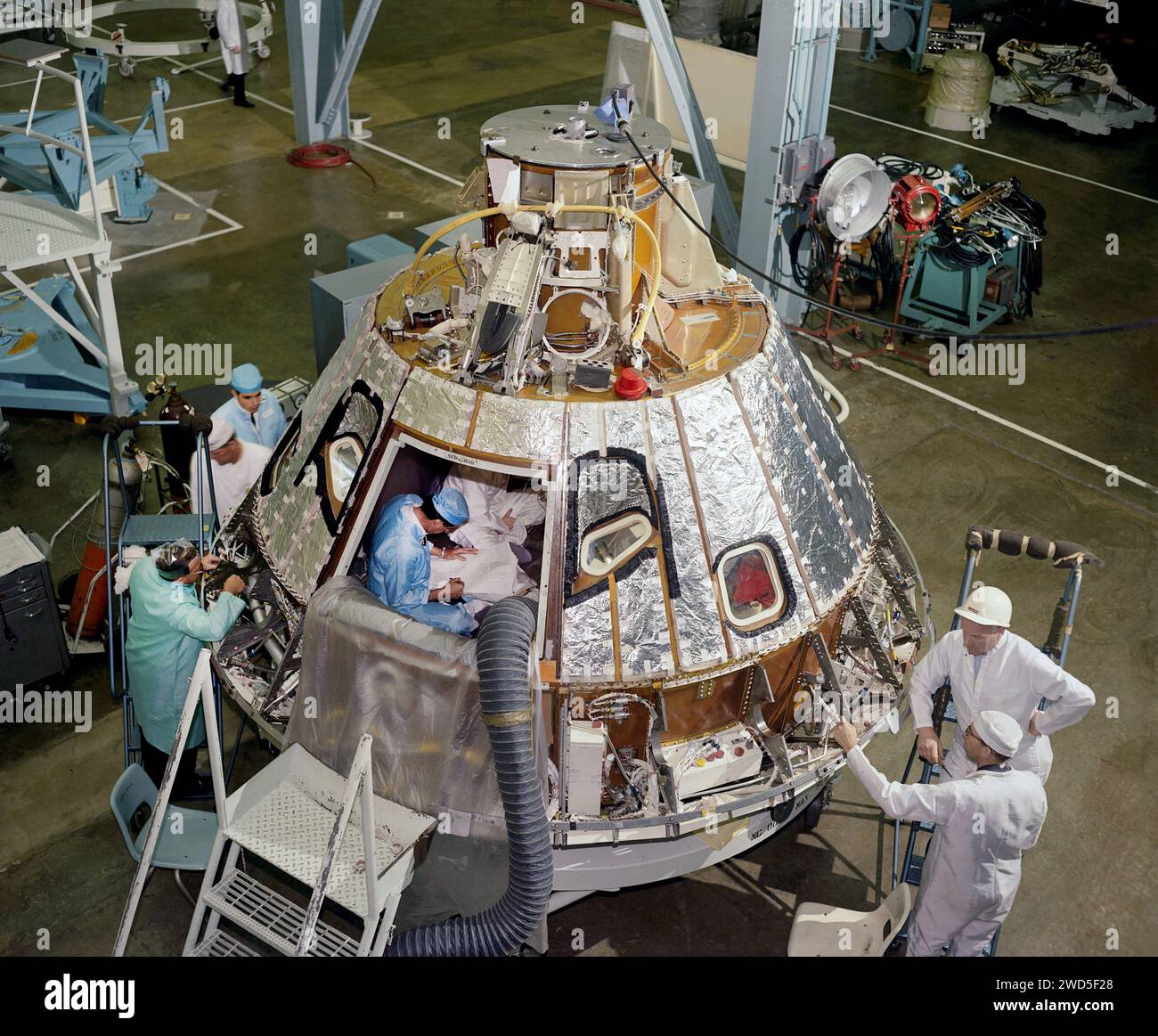 Vue à grand angle des mécaniciens travaillant sur la baie arrière du module de commande Apollo 1 Spacecraft 012, regardant vers l'axe -Z, pendant la préparation de l'installation du bouclier thermique du compartiment de l'équipage, North American Aviation, Californie, USA, NASA, 18 avril 1966 Banque D'Images