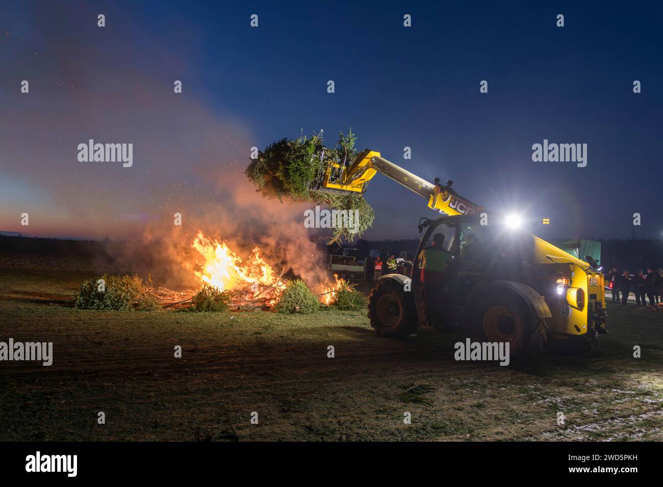 Un incendie d'avertissement lors d'un rassemblement d'agriculteurs et d'agriculteurs à cause des plans du gouvernement fédéral visant à couper les subventions, les arbres de Noël, les chargeuses sur pneus Banque D'Images