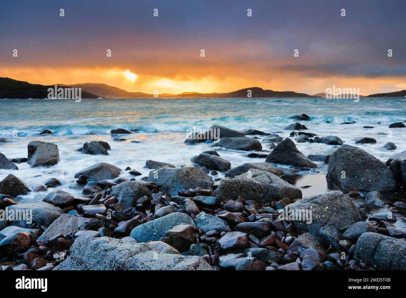 Ciel nuageux aux couleurs de l'atmosphère au lever du soleil sur une plage rocheuse près de Reiff sur la côte ouest de l'Écosse Banque D'Images