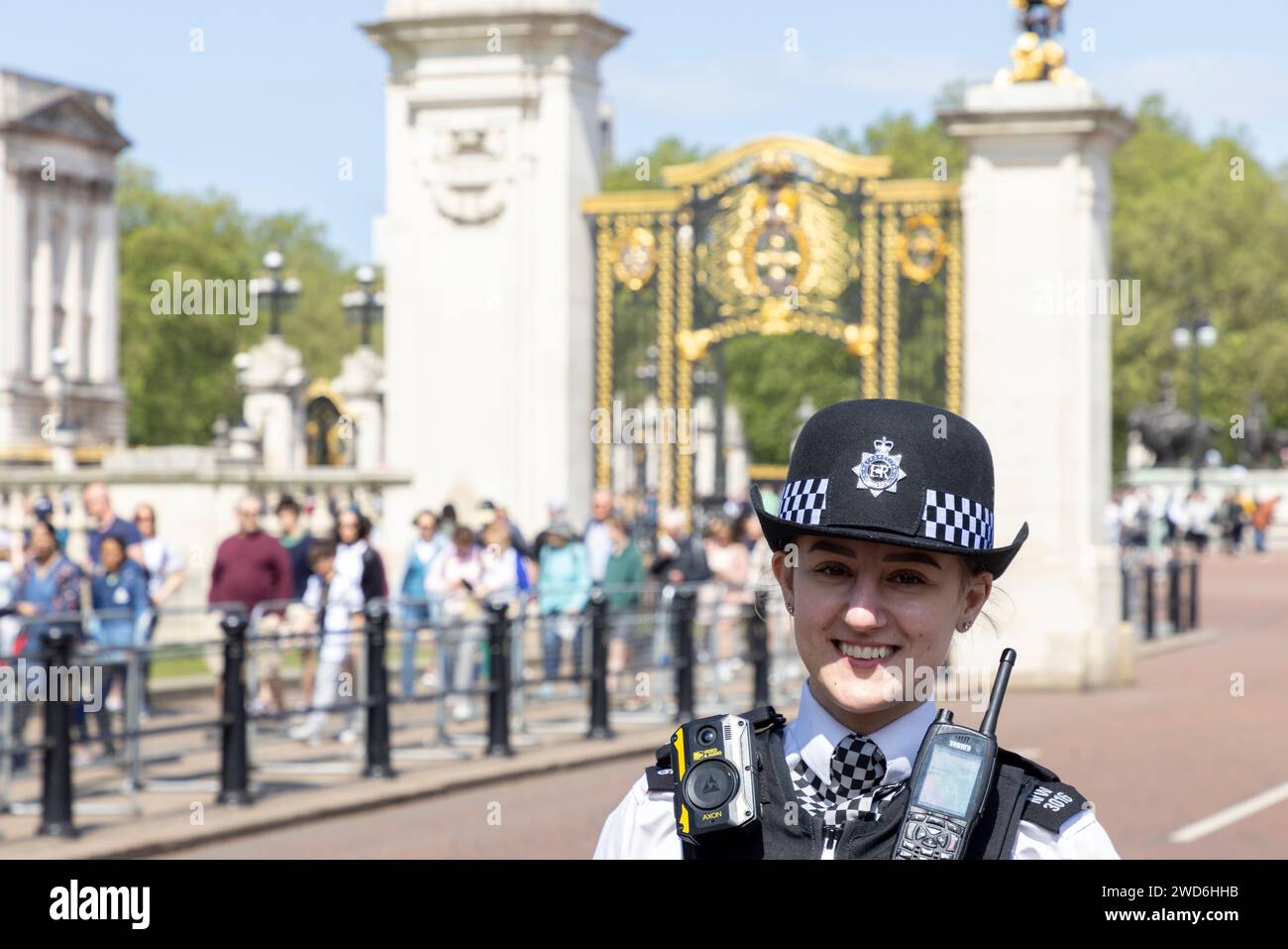 Une femme souriante officier de police devant Buckingham Palace, Londres Banque D'Images