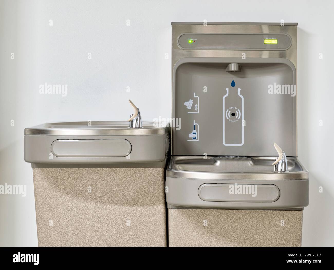 Station de remplissage de bouteilles d'eau avec deux fontaines isolées par un mur blanc Uni. Technologie écologique automatisée sans contact. Banque D'Images