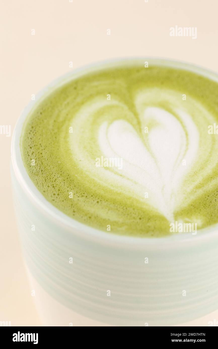 matcha latte sur une tasse sur un fond rose clair Banque D'Images