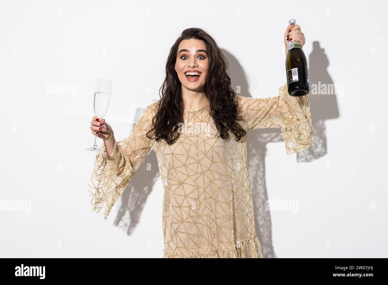 Femme en robe buvant du champagne de bouteille isolée sur un fond blanc Banque D'Images