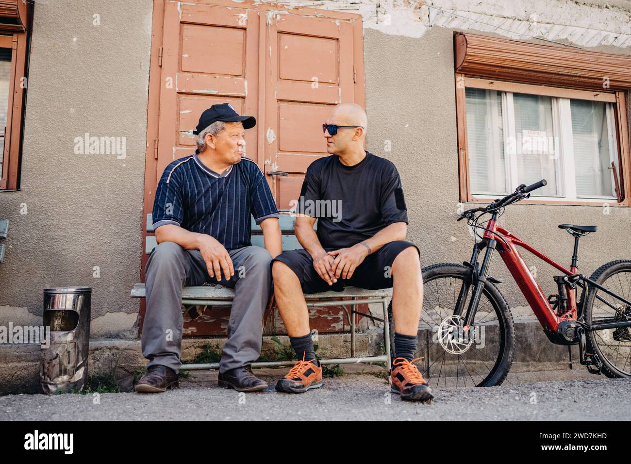 Vieux et jeune homme partage des expériences de conversations E-bike Banque D'Images