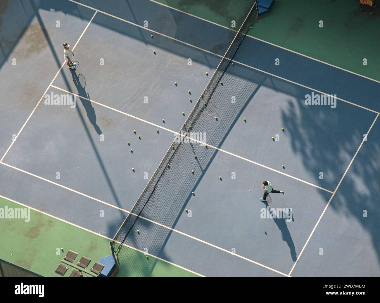 Les deux joueurs de tennis s'engagent dans un match amical en double sur un court de tennis inoccupé Banque D'Images