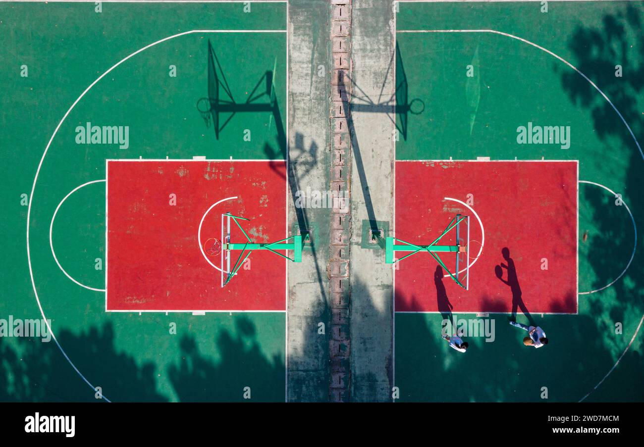 Un terrain de basket-ball dynamique avec un sol vert vif et une surface rouge contrastée Banque D'Images