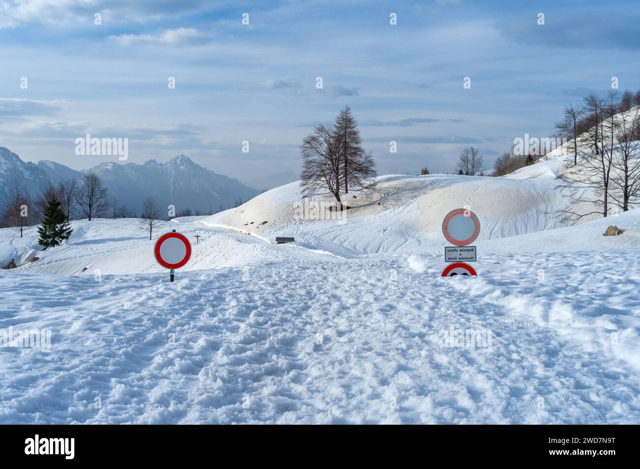 Panneaux routiers presque submergés dans la neige sur le col de Campogrosso en Italie. Banque D'Images