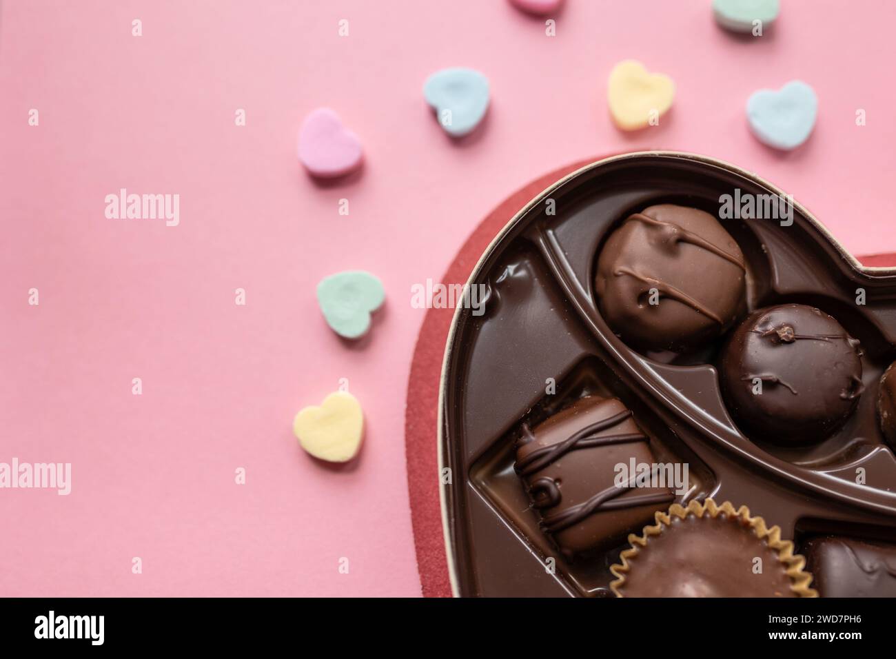 boîte de chocolats et coeurs de bonbons sur un fond rose Banque D'Images