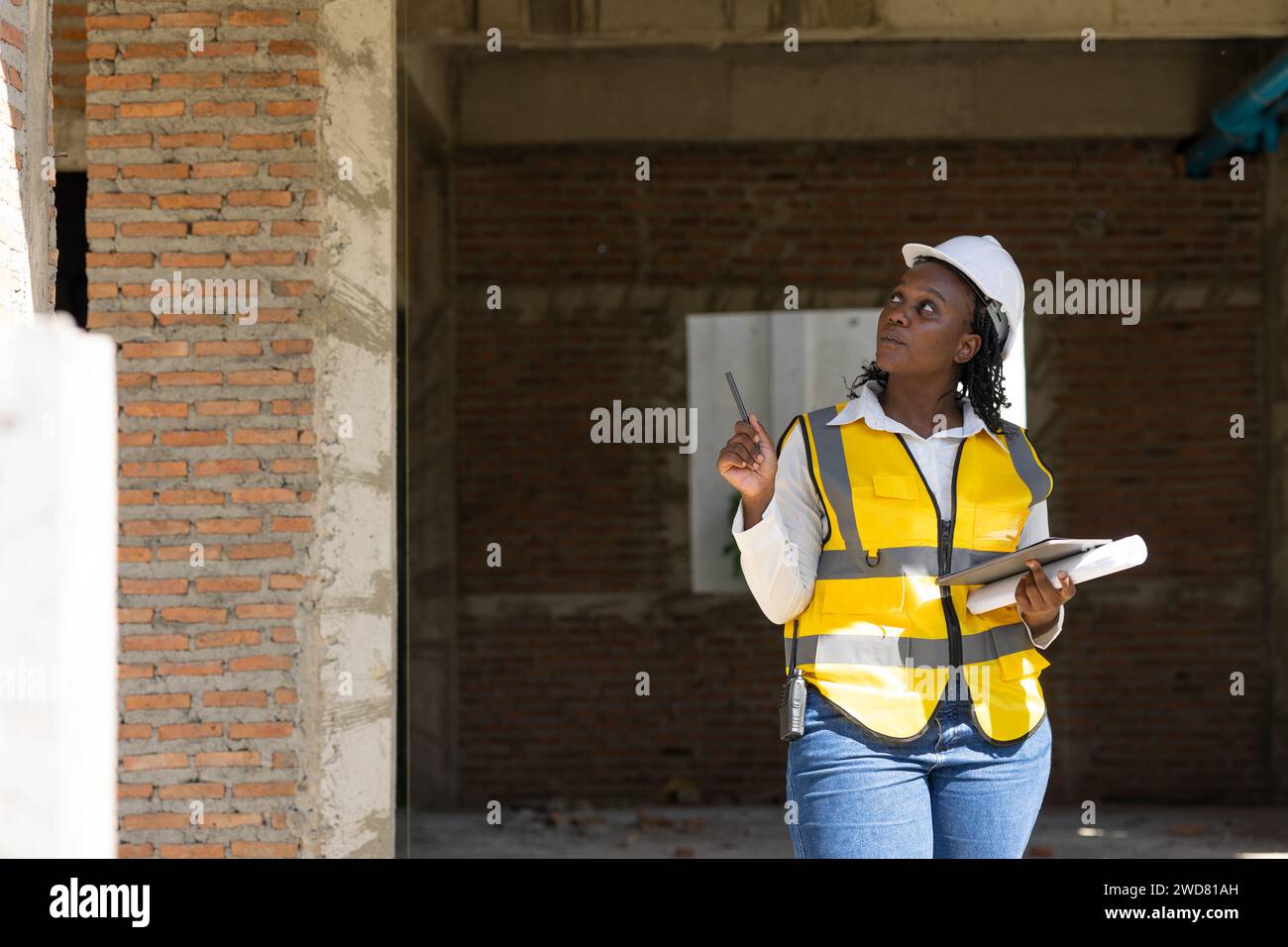 Les travailleuses noires africaines travaillent sur le chantier de construction pour le travail d'inspecteur de chantier vérifiant l'avancement du projet Banque D'Images