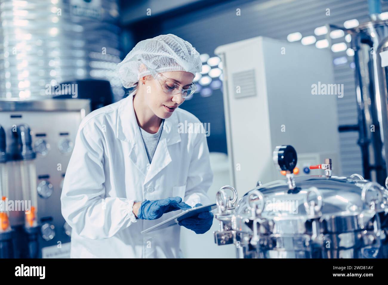 le personnel travaille dans l'usine de laboratoire médical de science vérifier le réservoir de pression d'enregistrement heureux de travail Banque D'Images