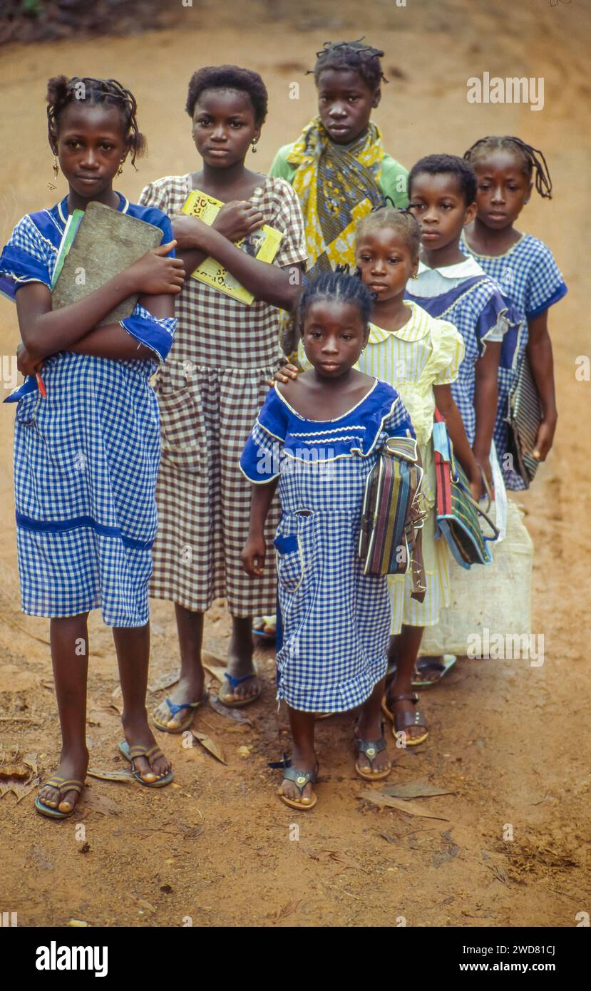 Côte d'Ivoire, Divo Girls sur le chemin de l'école marchant dans la queue. Banque D'Images