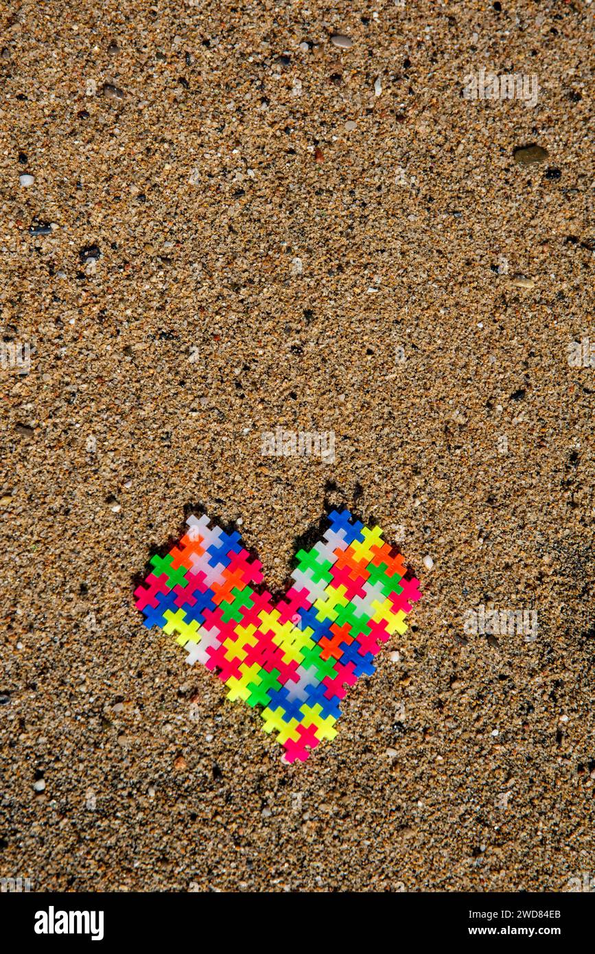 Puzzle Heart : amour et connexion représentés par des pièces de puzzle colorées sur la plage, symbolisant un lien unique et spécial Banque D'Images