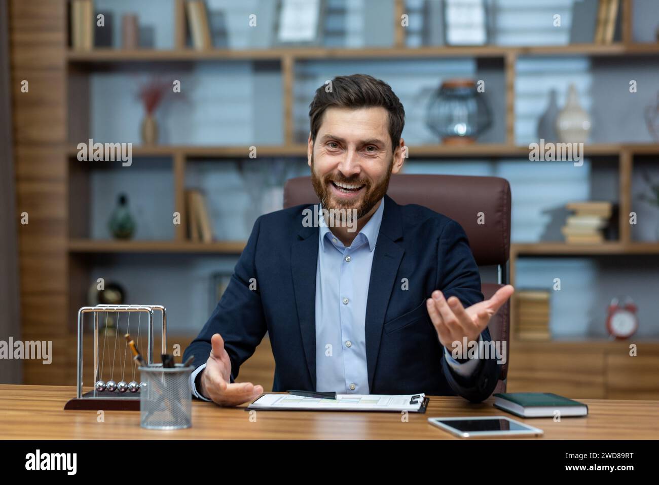 Professionnel mature souriant dans un bureau à domicile bien aménagé ayant une discussion amicale ou une entrevue Banque D'Images