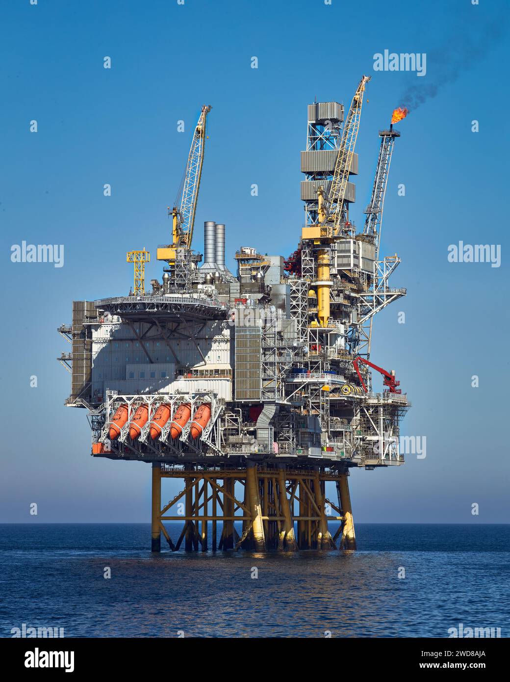 Plate-forme de jackup pétrolière et gazière offshore dans l'océan pendant la journée claire et lumineuse, avec le ciel bleu et l'eau calme. Banque D'Images
